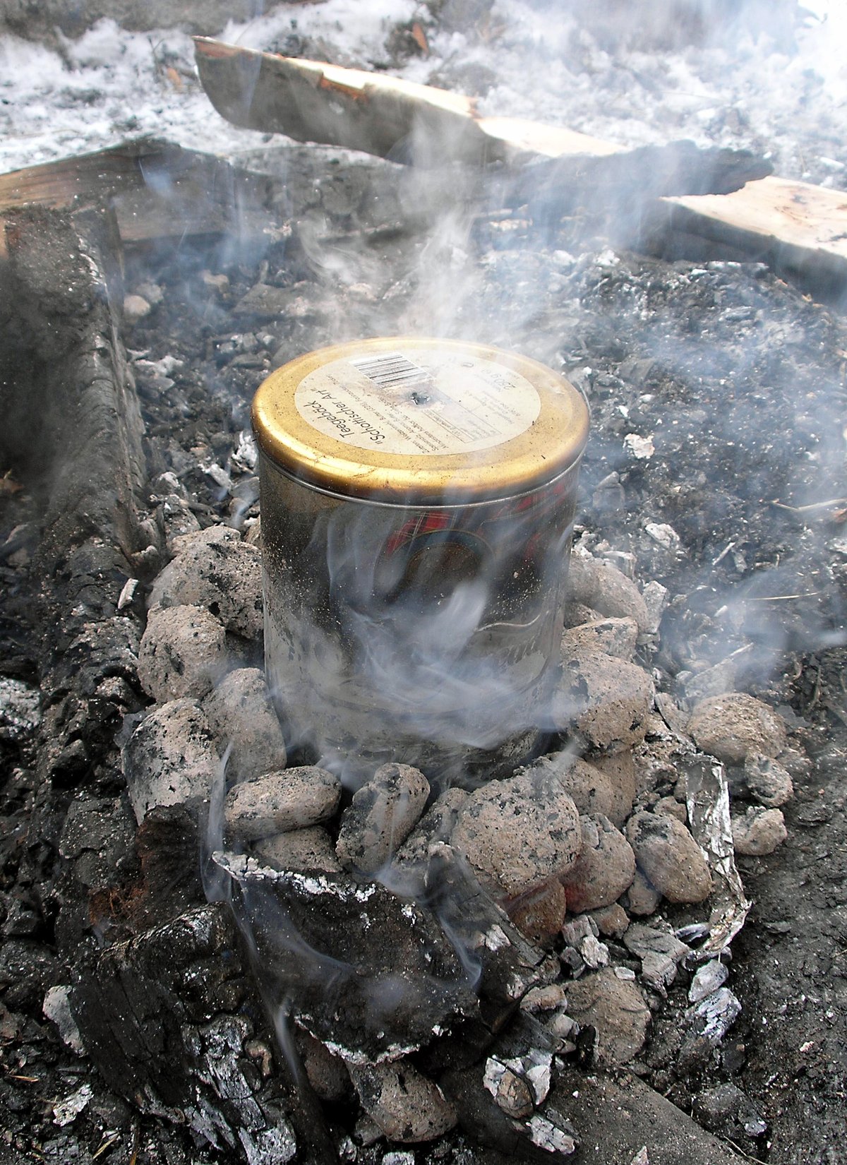 Dispositif expérimental de distillation de l'écorce de bouleau dans un récipient unique posé dans le feu