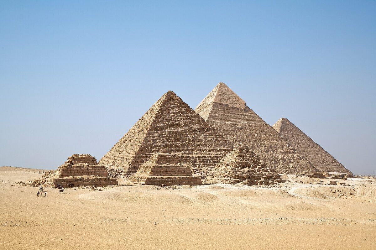 Les trois grandes pyramides du plateau de Gizeh alignées sous un ciel dégagé