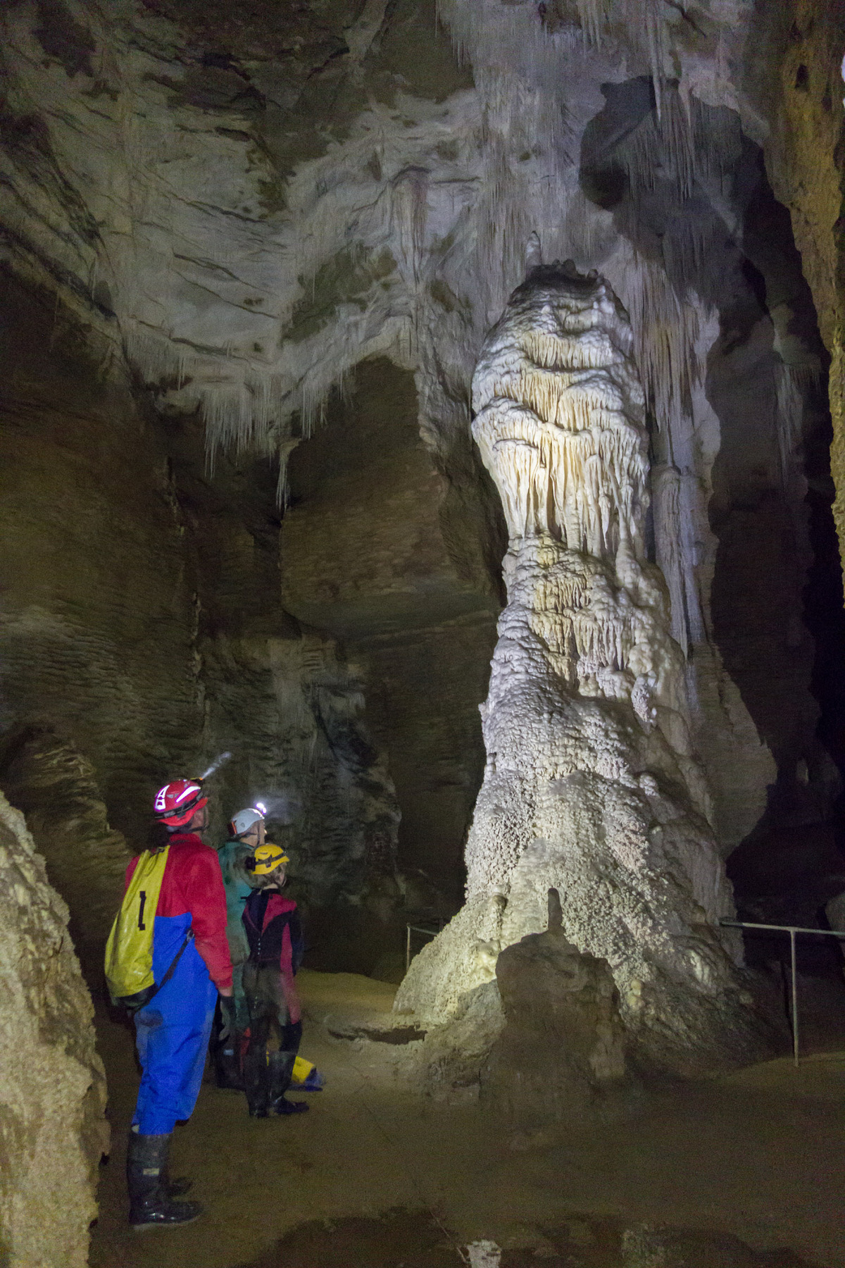 Salle profonde et obscure d'une grotte explorée par des spéléologues