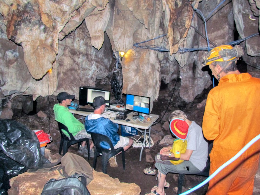 Scientists navigating the narrow passages of Rising Star Cave in South Africa