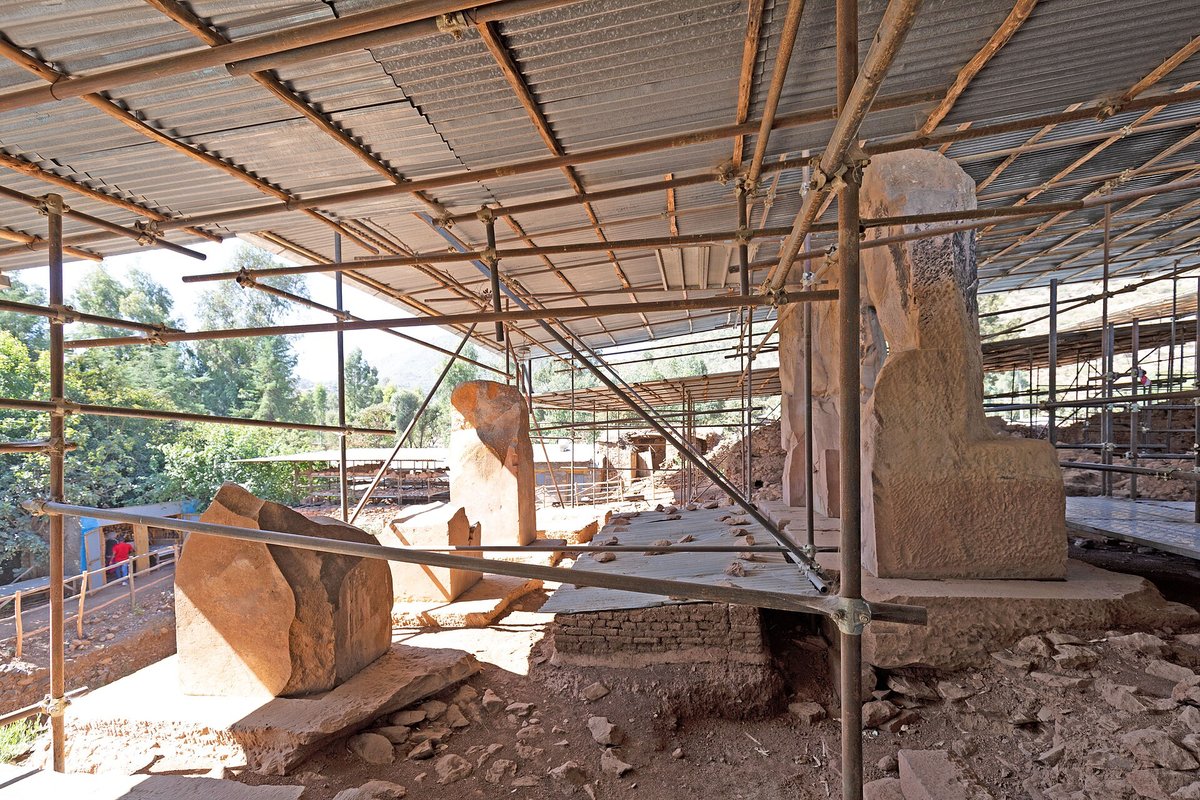 Large stone pillars of the entrance porch of the Grat Be'al Gibri palace, beneath a metal protective shelter