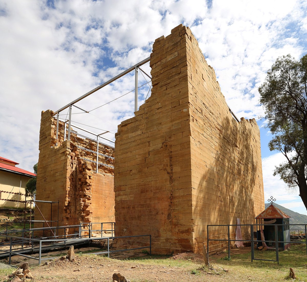 The Great Temple of Yeha, a tall wall of finely dressed limestone blocks under a cloudy sky